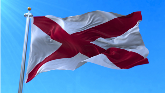 Alabama state flag showing the crimson cross clearly, while it is waving in the wind.