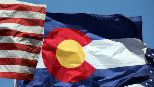 The flag of Colorado flying next to the US flag.