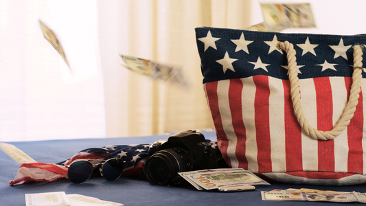 Modern Tote bag with American Flag design printed on it. The bag is sitting on the table with some travel items next to it.