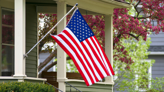 US Flag displayed outside a family home on a wall-mounted flag pole