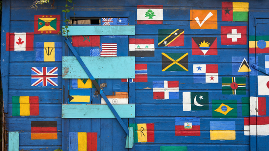 Flags from around the world hand painted on a rustic blue painted wooden hut