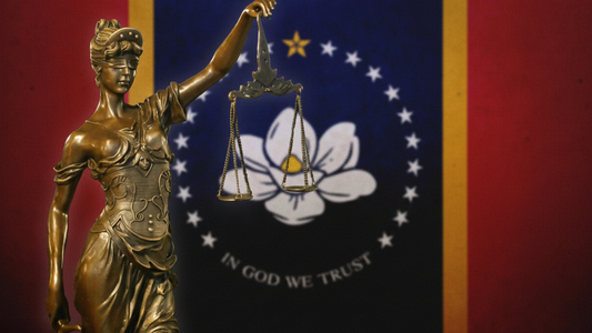 Mississippi state flag displayed on wall with the lady of justice statue in front
