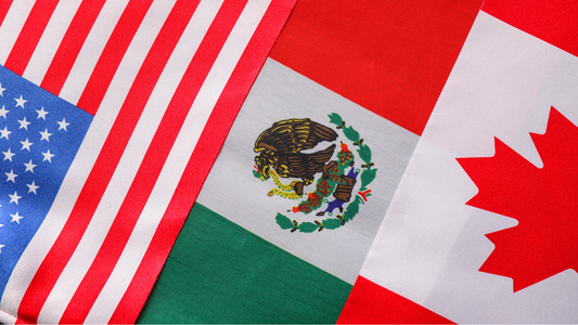 Close-up of North American Flags - US, Mexico, & Canada displayed side by side on a flat surface