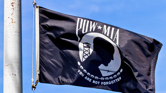 A close-up of a waving POW Flag with the words "You are not forgotten" clearly visible.
