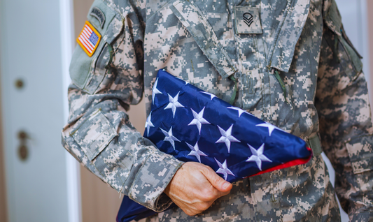 Soldier presenting US Flag folded