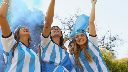 Excited fans of Argentina wearing Argentina's Blue and White colors depicting the Argentina flag. 