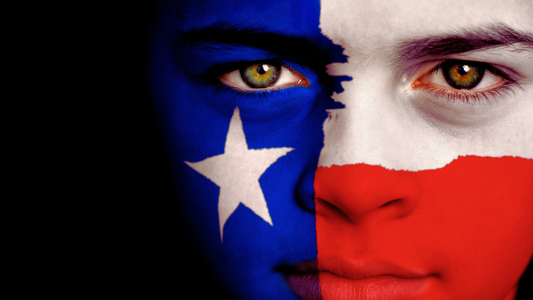 Close-up of a girl with the Texas Flag painted on her face with a black background
