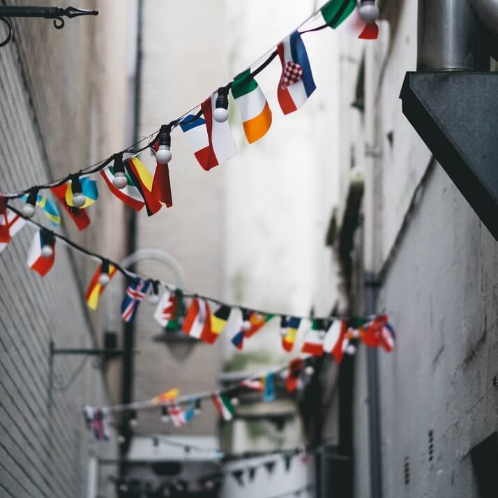 Flags of different countries hanging in a street